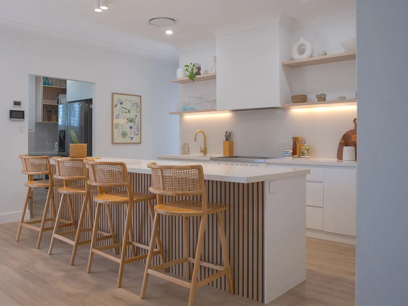 Modern kitchen with white island, bar stools and open shelving in the showroom